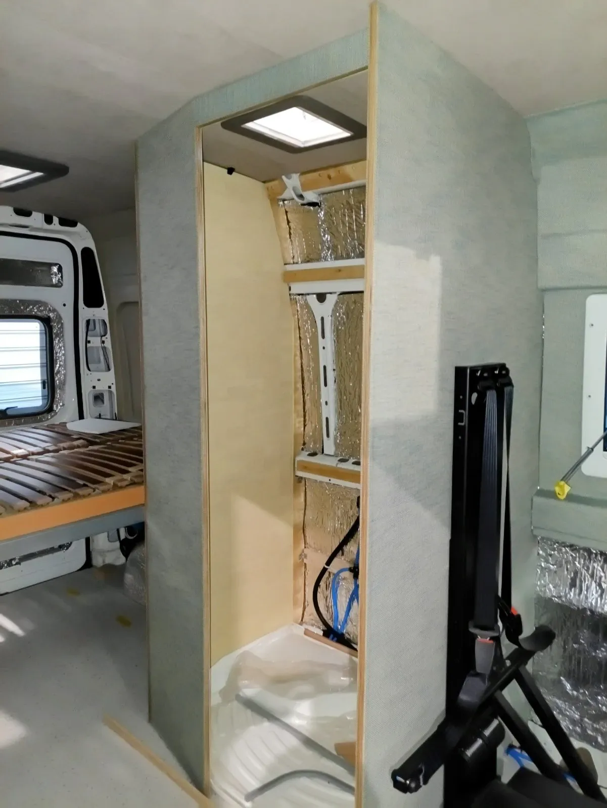 Shower cubicle mid-build, upholstered in pale fabric